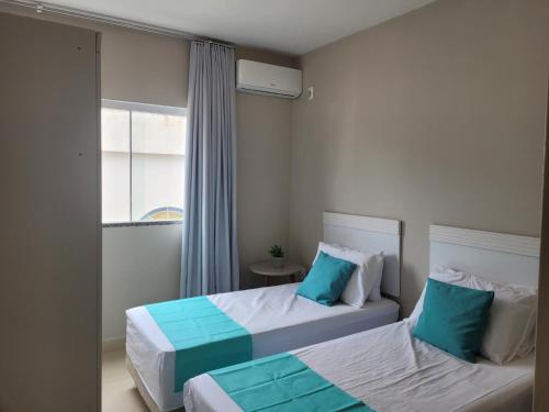 a bedroom with two beds with blue and white at Apartamento completo no centro de Tijucas 105 in Tijucas
