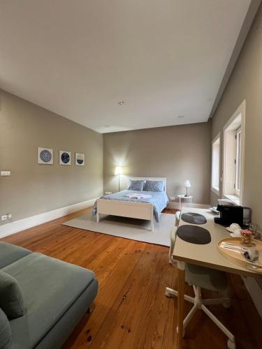 1 dormitorio con cama y escritorio. en GROW- Casa Parque da Cidade, en Oporto