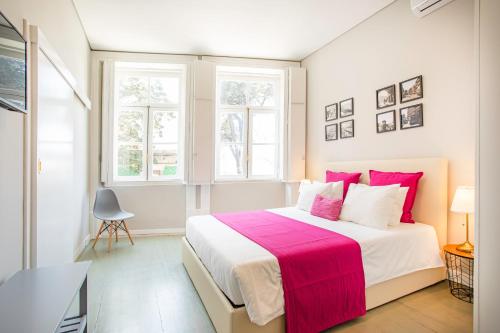 a white bedroom with a large bed with a pink blanket at Alegria Colour Apartments in Porto
