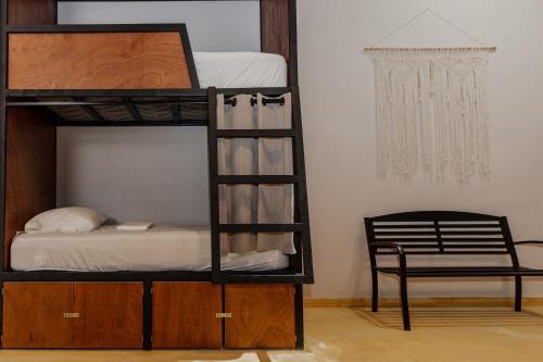 a bedroom with a bunk bed with a chair and a chandelier at Caleta Hostel Rooftop & Pool in Cancún