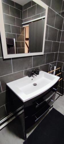 une salle de bain avec un lavabo blanc et un miroir dans l'établissement 202 Duplex à colombage en plein centre ville, à Bourges