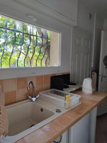 una cucina con un grande lavandino e una finestra di Chambre privée avec parking a Nîmes