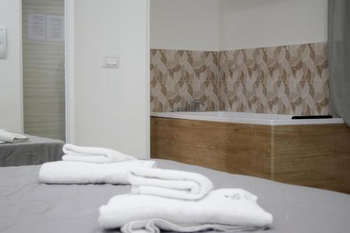 een badkamer met een bad en 3 handdoeken bij B&B Villa Anna in Paestum