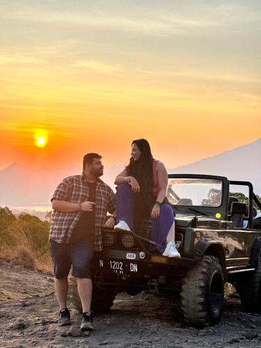 a man and a woman sitting on the back of a truck at Batur volcano sunrise jeep in Kubupenlokan