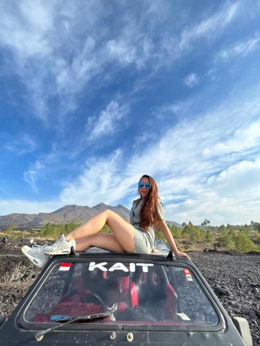a woman sitting on the roof of a car at Batur volcano sunrise jeep in Kubupenlokan