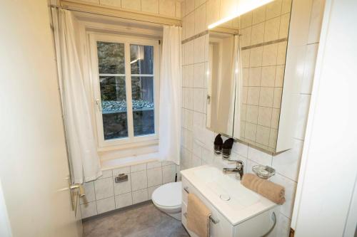 bagno con servizi igienici, lavandino e finestra di Villa Hartenfels 1 a Scuol