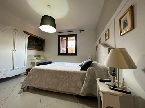 - une chambre avec un lit et une table avec une lampe dans l'établissement Appartamento con giardino a 5 min dal Mare - Burlamacco House, à Viareggio