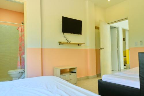 1 dormitorio con 1 cama y TV en la pared en Casa en cartagena con jacuzzi en Cartagena de Indias