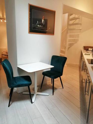 une cuisine avec une table et deux chaises et un escalier dans l'établissement Duplex situé dans le centre de St Valery en Caux, à Saint-Valery-en-Caux