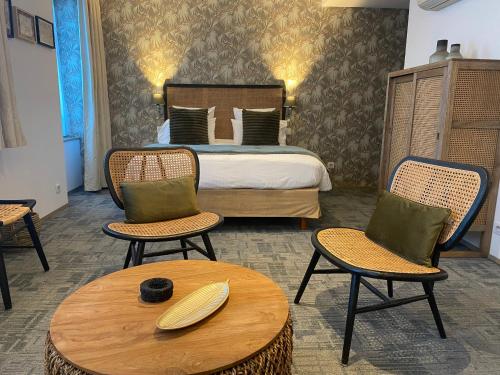 コンカルノーにあるCit'Hotel Hôtel de France et d'Europeのベッド1台、椅子2脚、テーブルが備わる客室です。