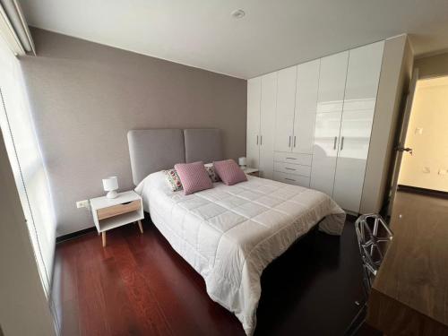 1 dormitorio con 1 cama con 2 almohadas rosas en El Golf los inkas luxury Penthouse, en Lima