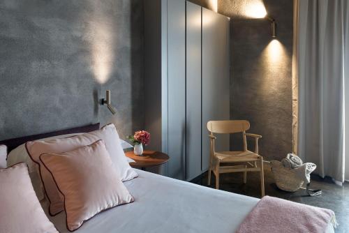 a bedroom with a white bed and a chair at Dimora Cottanera in Castiglione di Sicilia
