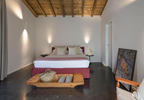a bedroom with a large bed and a wooden table at Dimora Cottanera in Castiglione di Sicilia