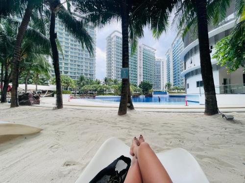 a woman laying on a chair on a beach at Azure Staycation Near the Airport in Manila