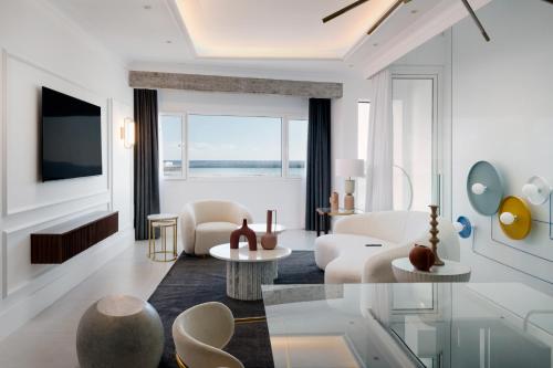 Elle comprend un salon doté d'un mobilier blanc et d'une grande fenêtre. dans l'établissement Blue Marina Suites - Boutique Apartments, à Arrecife