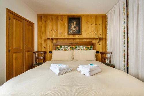 a bedroom with a bed with two towels on it at LUVI - Courmayeur in Courmayeur