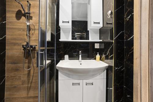 uma casa de banho com um lavatório branco e um chuveiro em La Casa 177 - 4 em Fréjus