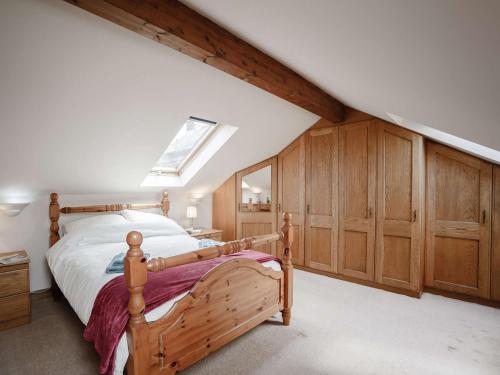 a bedroom with a bed and wooden cabinets and a skylight at 3 bed property in Wigton 83471 in Aikton