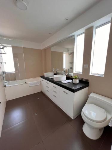 a bathroom with a toilet and a sink and a tub at El Golf los inkas luxury Penthouse in Lima