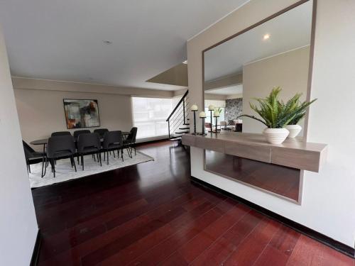 comedor y sala de estar con mesa y sillas en El Golf los inkas luxury Penthouse, en Lima