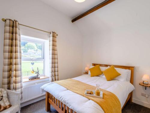 una camera da letto con un letto con cuscini gialli e una finestra di 2 Bed in Lydbrook 83665 a Lydbrook