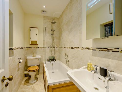 a bathroom with a sink and a toilet and a tub at 2 bed property in Wareham 83814 in Morden