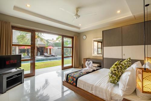a bedroom with a bed and a tv in a room at Villa 500m2 with 14m Pool, BBQ, Pinball - Seminyak in Seminyak
