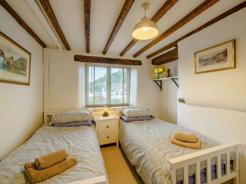 two twin beds in a room with a window at 3 bed in Backbarrow 85686 in Backbarrow