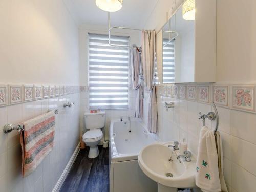 La salle de bains blanche est pourvue d'un lavabo et de toilettes. dans l'établissement 4 Bed in Holmfirth 86032, à Purmerend