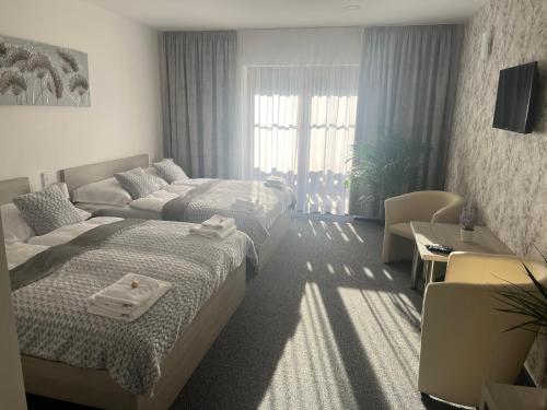 a hotel room with two beds and a couch at Hospůdka na konci světa in Nový Jičín