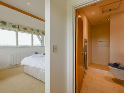 a bedroom and a bathroom with a bed and a tub at 4 Bed in East Cowes 87819 in Newport