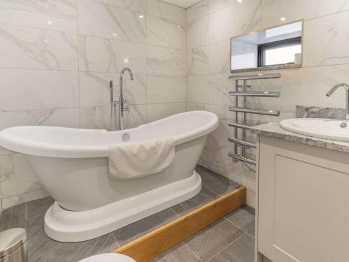 a white bathroom with a tub and a sink at 2 bed property in Cowbridge 87576 