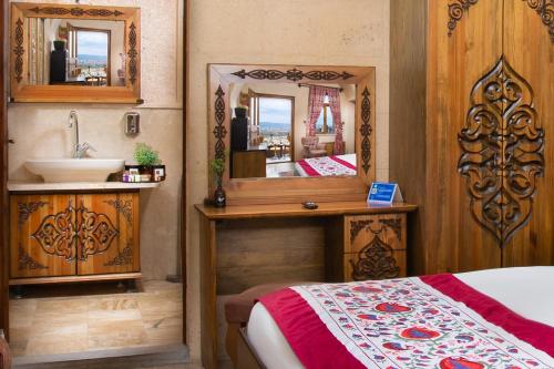a bathroom with a bed and a sink and a mirror at Simera in Cappadocia - Special Class - Best View Rooftop in Uchisar