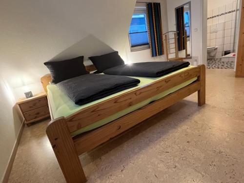 a bedroom with a large wooden bed with black pillows at Astrid's Pension in Winterberg