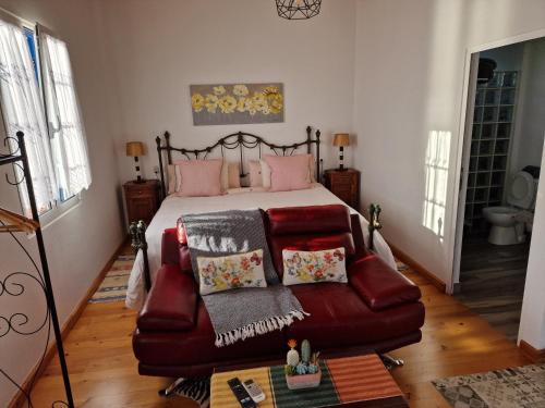 a bedroom with a bed and a couch with pillows at Casa Villa Dinastía Sótão Y Casa Villa Dinastía Miramar in Ribeira Brava