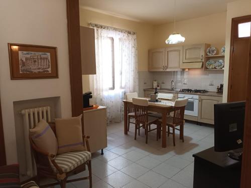 een keuken en eetkamer met een tafel en stoelen bij La casa del ponte romano in Pogi