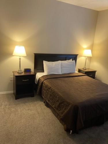 ein Schlafzimmer mit einem großen Bett mit zwei Lampen an Tischen in der Unterkunft Home Street at Bracken House in Pittsburgh