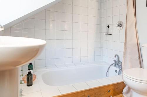 a bathroom with a tub and a sink and a toilet at Lovely 2 BD with stunning views over Stroud valley 