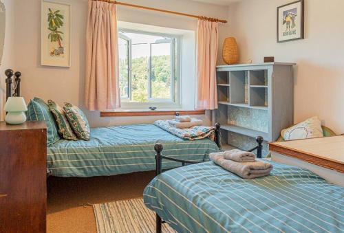 1 dormitorio con 2 camas y ventana en Lovely 2 BD with stunning views over Stroud valley 