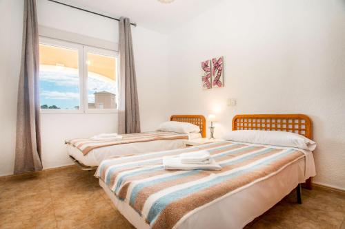 Dos camas en una habitación con ventana. en Villa Zelda - PlusHolidays, en Calpe