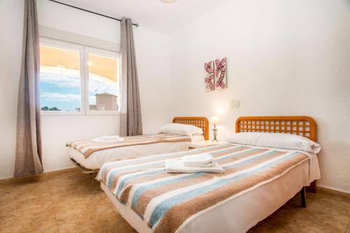 two beds in a room with a window at Villa Zelda - PlusHolidays in Calpe