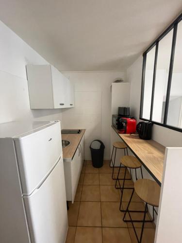 una piccola cucina con frigorifero bianco e bancone di Charmant F3 à Longjumeau a Longjumeau