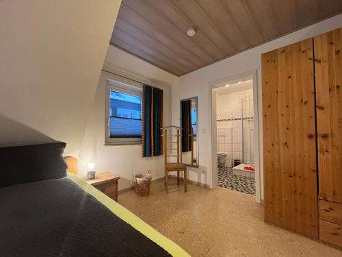 a bedroom with a bed and a bathroom with a shower at Astrid's Pension in Winterberg