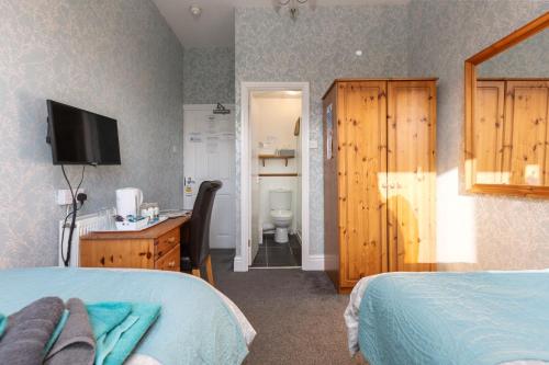 a bedroom with a bed and a bathroom with a toilet at The Fairmile in Lytham St Annes