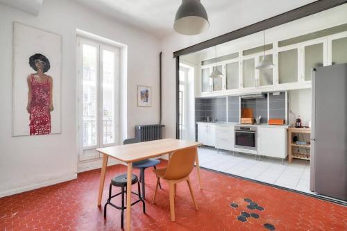 - une cuisine avec une table, des chaises et une femme sur le mur dans l'établissement Splendide T2 avec balcon à 10 min du Vieux Port, à Marseille