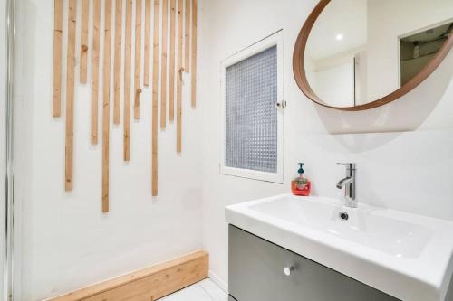 une salle de bain avec un lavabo et un miroir au mur dans l'établissement Splendide T2 avec balcon à 10 min du Vieux Port, à Marseille
