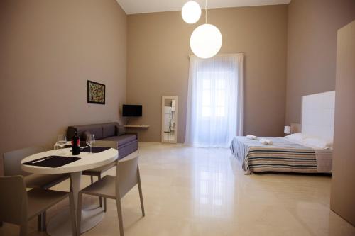 a room with a bed and a table and a couch at Central Gallery Rooms- Palazzo D'Ali' Staiti XIX in Trapani