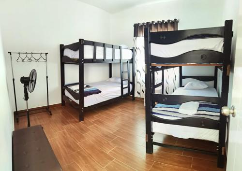 a room with two bunk beds and a wooden floor at Bungalow Sol del Sur in Paracas