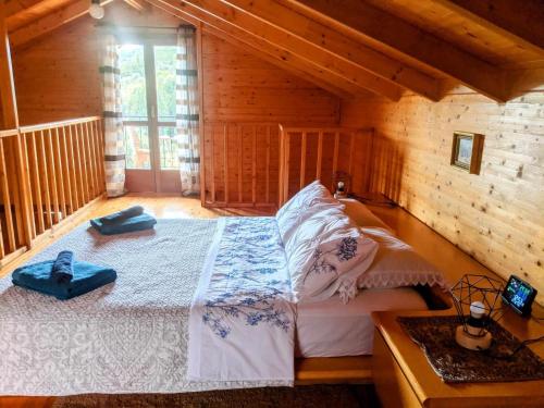 1 dormitorio con 1 cama en una cabaña de madera en Olive Grove Chalet, en Nafpaktos