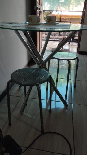 a glass table and two chairs under a glass table at Anchia - Hostel in Alajuela City